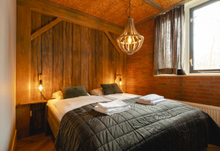 Gemütliches Schlafzimmer in der Baby & children bungalow im Holiday Park Mölke, Niederlande, mit Holzwänden.
