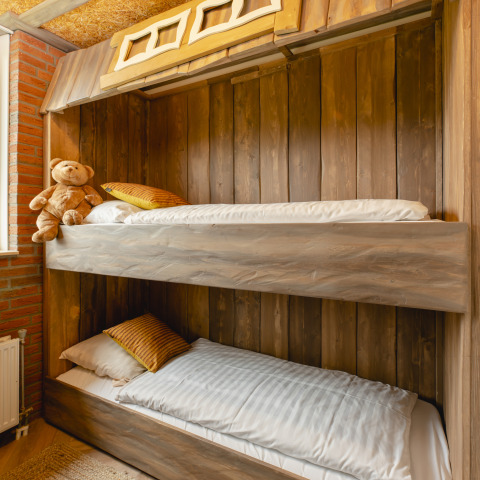 Gezellige kamer met stapelbedden en teddybeer in Baby & Children Bungalow, Holiday Park Mölke, Nederland.