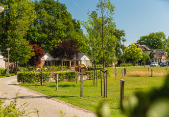 Vakantiehuisjes en speeltuin bij Baby & children bungalow in Holiday Park Mölke, Nederland, op een zonnige dag.