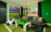 Football-themed lodge room at FC Mölke stadium in Holiday Park Mölke, Netherlands, with green decor.