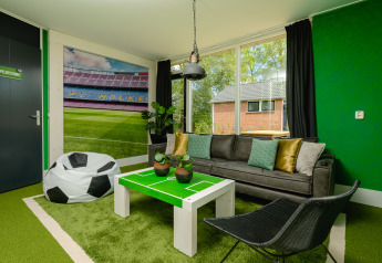 Football-themed lodge room at FC Mölke stadium in Holiday Park Mölke, Netherlands, with green decor.