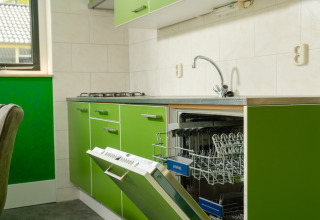 Groene keuken in de FC Mölke stadion lodge met open vaatwasser bij Holiday Park Mölke in Nederland.
