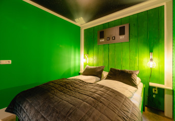 Slaapkamer in de FC Mölke Stadion-lodge in Holiday Park Mölke, Nederland, met groene wanden en sportstijl.