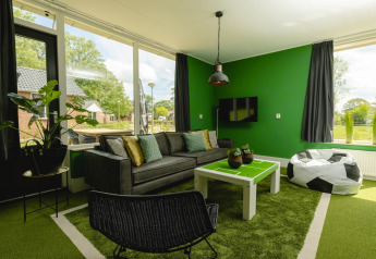 Woonkamer in FC Mölke stadion lodge bij Vakantiepark Mölke in Nederland met voetbalthema inrichting.