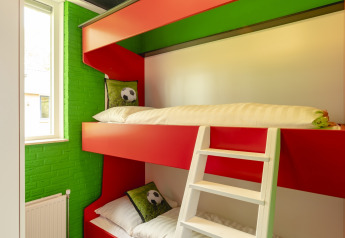 A bright room with bunk beds and football decor at FC Mölke stadium in Holiday Park Mölke, Netherlands.