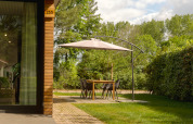 Coin repas extérieur avec parasol à côté d'une cabane en bois au Holiday Park Mölke, Pays-Bas.