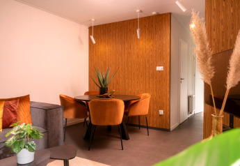 Moderne woon- en eetkamer in Tiny Cabin bij Holiday Park Mölke, Nederland, met warme houtaccenten.