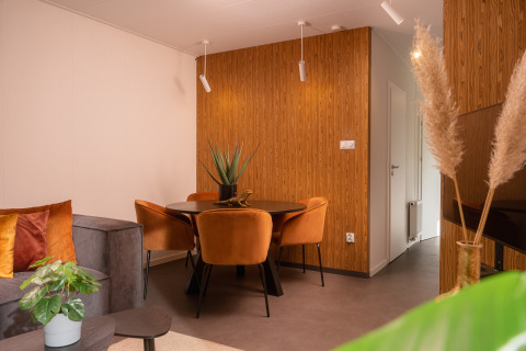 Modernes Wohnzimmer und Essbereich in der Tiny Cabin im Holiday Park Mölke, Niederlande, mit Holzdekor.