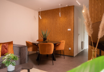 Soggiorno e sala da pranzo moderni nella Tiny Cabin al Holiday Park Mölke, Paesi Bassi, con accenti in legno.