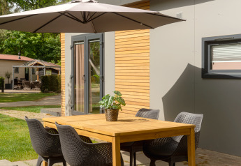 Table à manger extérieure avec chaises et parasol près de la Tiny Cabin au Holiday Park Mölke, Pays-Bas.