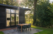 Sunny morning at the Nature Cabin with a modern outdoor dining set at Holiday Park Mölke, Netherlands.