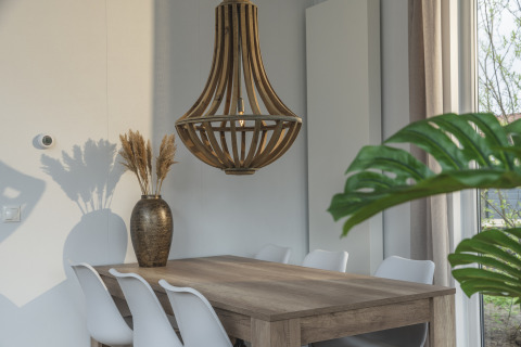 Dining area at Cosy Cabin in Holiday Park Mölke, Netherlands, featuring wooden table and modern decor.