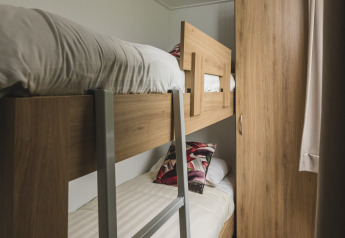Gemütliches Schlafzimmer mit Etagenbett und Kleiderschrank in der Cosy Cabin im Holiday Park Mölke, Niederlande.
