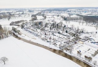 Luftaufnahme der River Lodge im Holiday Park Mölke in den Niederlanden, umgeben von verschneiter Landschaft.
