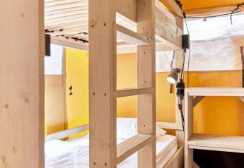 Interieur van een safaritent met stapelbedden en houten planken in Villatent Outback.