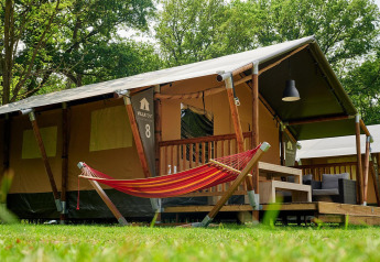 Safari-telt Villatent Nomad med hængekøje og terrasse i Recreatiepark de Lucht, Holland, omgivet af træer