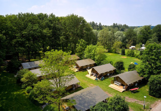 Luftfoto af Villatent Nomad safaritelte på Recreatiepark de Lucht omgivet af grønne træer i Holland.