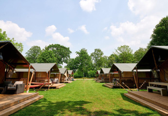 Safari telte på Recreatiepark de Lucht i Holland med grønne omgivelser og blå himmel om sommeren.