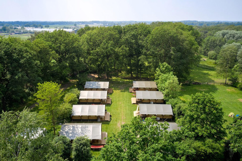 Luchtzicht op Villatent Nomad safaritenten bij Recreatiepark de Lucht, Nederland, tussen het groen.