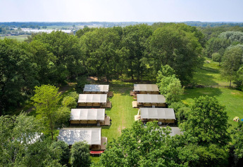 Luftfoto af Villatent Nomad safaritelt ved Recreatiepark de Lucht, Holland, omgivet af grøn natur.