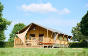 Tienda safari Villatent Nomad en Camping Betuwe, Países Bajos, vista exterior en un día soleado con césped verde.