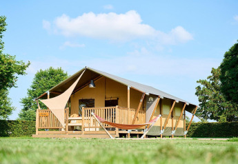 Safari-telt Villatent Nomad på Camping Betuwe i Holland, set udefra på en solrig dag med grøn græsplæne.