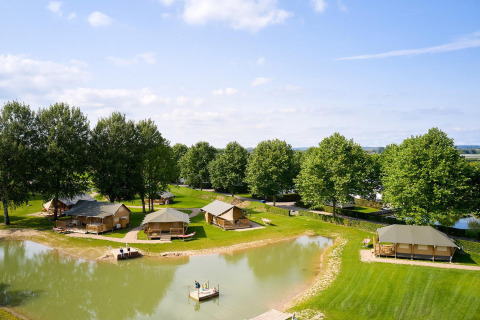 Vista aérea de las tiendas safari Villatent Nomad junto a un estanque en Camping Betuwe, Países Bajos.