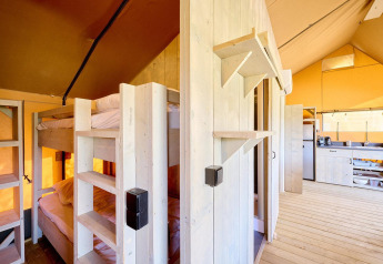 Vue intérieure de la tente safari Villatent Ranger avec lits superposés, sol en bois et cuisine équipée.