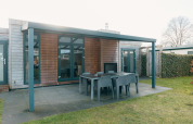Patio esterno con tavolo da pranzo e sedie presso Veluwe Villa + sauna, Holiday park De Boshoek, Paesi Bassi.