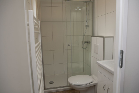 Baño moderno con ducha, inodoro e interior blanco en Veluwe Villa + sauna, Holiday park De Boshoek, Países Bajos.