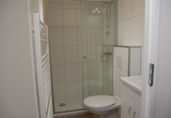 Salle de bain moderne avec douche, toilettes et intérieur blanc à Veluwe Villa + sauna, Holiday park De Boshoek, Pays-Bas.