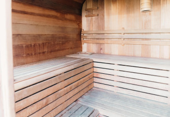 Innenaufnahme einer Holzsauna in der Veluwe Villa mit geräumigen Bänken und hellem Holzdekor.