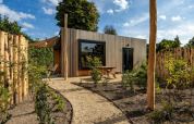 Moderna Tiny Wellness Cabin al Holiday Park De IJsvogel nei Paesi Bassi, immersa nel verde del giardino.