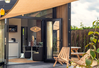 Cozy patio and modern interior of a Tiny Wellness Cabin at Holiday Park De IJsvogel in the Netherlands.