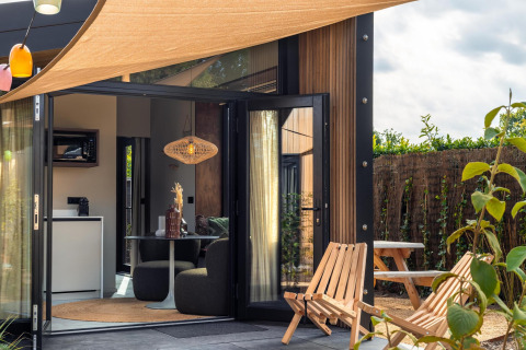 Hyggelig terrasse og moderne interiør i en Tiny Wellness Cabin ved Holiday Park De IJsvogel, Holland.