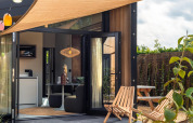 Cozy patio and modern interior of a Tiny Wellness Cabin at Holiday Park De IJsvogel in the Netherlands.