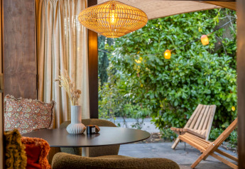 Hyggelig indretning i Tiny Wellness Cabin på Holiday Park De IJsvogel med udsigt til grøn have.