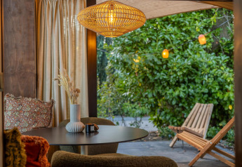 Accogliente interno della Tiny Wellness Cabin all’Holiday Park De IJsvogel con vista su un rigoglioso giardino.