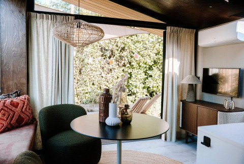 Intérieur lumineux et moderne de la Tiny Wellness Cabin au Holiday Park De IJsvogel, vue sur le jardin.