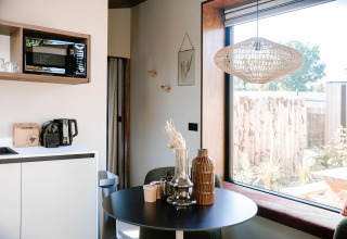 Tiny Wellness Cabin al Holiday Park De IJsvogel con angolo cottura moderno e grande finestra, Paesi Bassi.