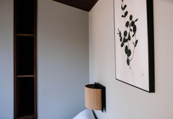 Interno della Tiny Wellness Cabin a Holiday Park De IJsvogel con quadro, mensola e applique a muro.