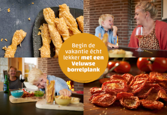 Et hyggeligt øjeblik i et tiny house med snacks, ostestænger og tomater på en Veluwse borrelplank.