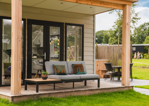 Panorama Lodge mit Hot Tub im Vakantiepark Hölte, Niederlande, mit moderner Terrasse und Gartenmöbeln.