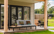 Panorama Lodge met hot tub bij Vakantiepark Hölte, Nederland, met moderne buitenterras en tuinmeubels.