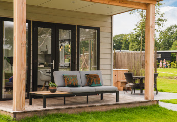 Panorama Lodge met hot tub bij Vakantiepark Hölte, Nederland, met moderne buitenterras en tuinmeubels.