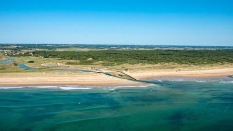 Aerial view of the beach and ocean at Camping Le Bois de la Gachère, Pays de la Loire, France, on a sunny day.