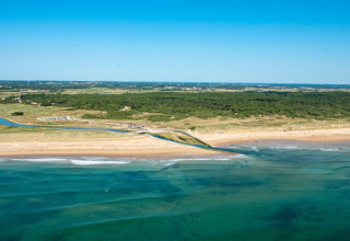 Aerial view of the beach and ocean at Camping Le Bois de la Gachère, Pays de la Loire, France, on a sunny day.