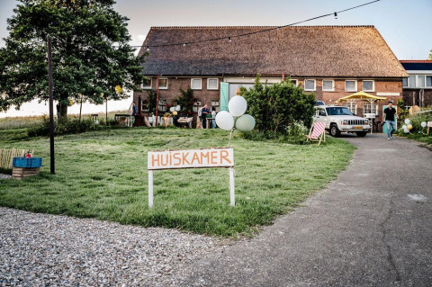 Bild des Safari-Zelts Cozy mit Frühstück bei TinyParks Cast Away in den Niederlanden mit 'Huiskamer'-Schild.