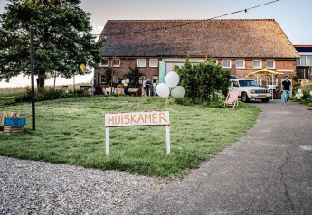 Bild des Safari-Zelts Cozy mit Frühstück bei TinyParks Cast Away in den Niederlanden mit 'Huiskamer'-Schild.