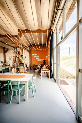 Interior de una tienda safari con decoración acogedora, mesa de comedor y luz natural, en los Países Bajos.
